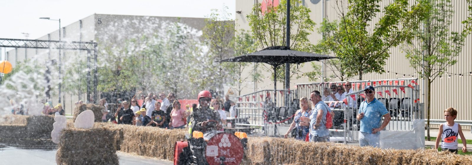 Medewerkers van Katoen Natie nemen deel aan zeepkistenrace tijdens familiedag.